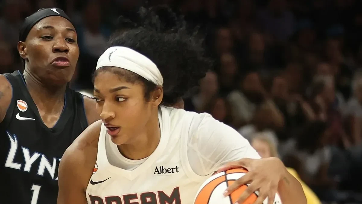 Angel Reese of the Atlanta Dream, in a white number 5 Dream jersey, drives with the ball against the Minnesota Lynx at Target Center
