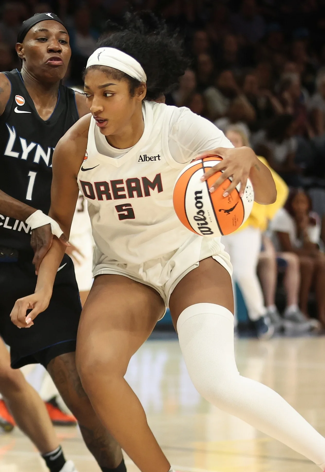 Angel Reese of the Atlanta Dream in a white number 5 jersey, looking up with her mouth open at Target Center