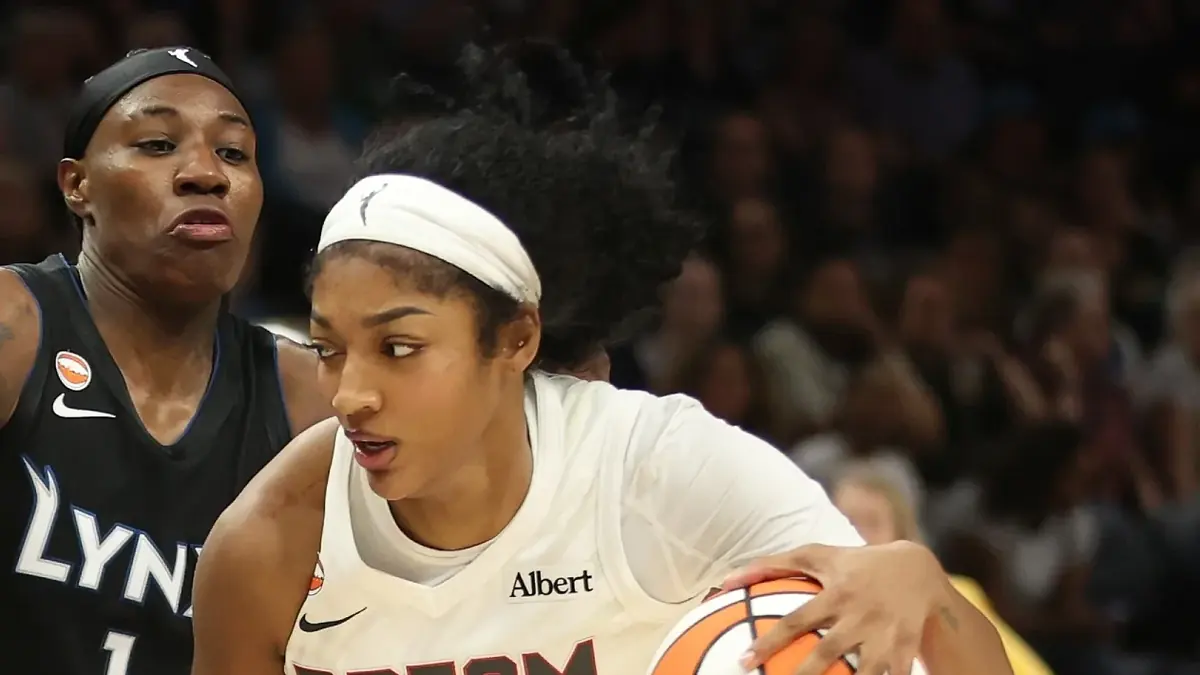 Angel Reese of the Atlanta Dream in a white number 5 jersey, looking up with her mouth open at Target Center