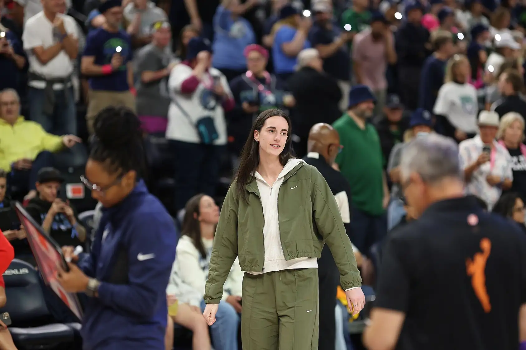 Caitlin Clark of the Indiana Fever in a white jersey dribbling the ball with her right hand