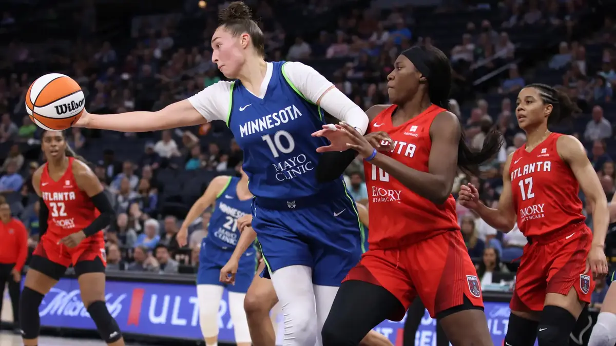 Rhyne Howard of the Atlanta Dream, in a white number 10 jersey, shoots a jumper against the Minnesota Lynx at Target Center