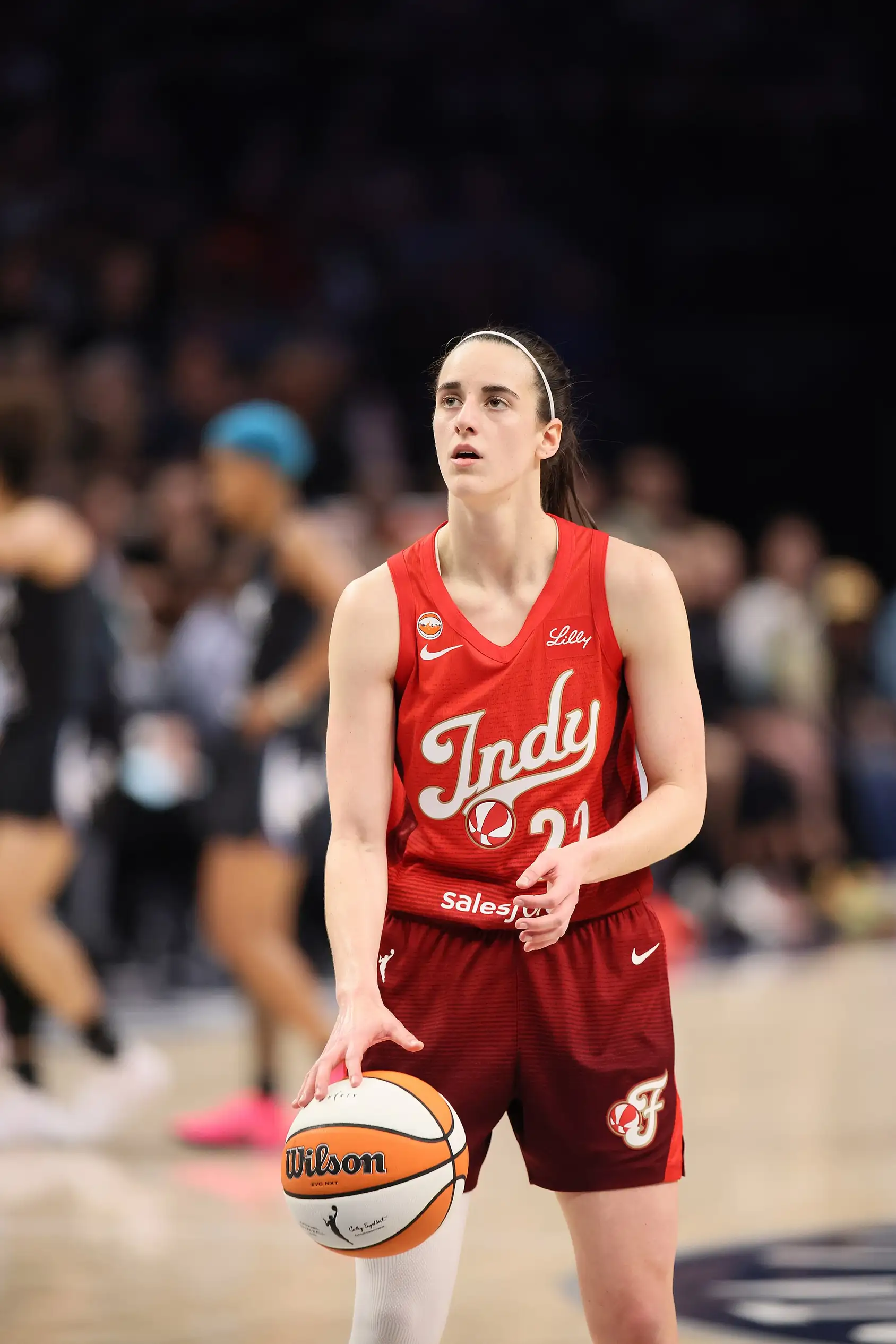 Caitlin Clark of the Indiana Fever dribbling in a white jersey.