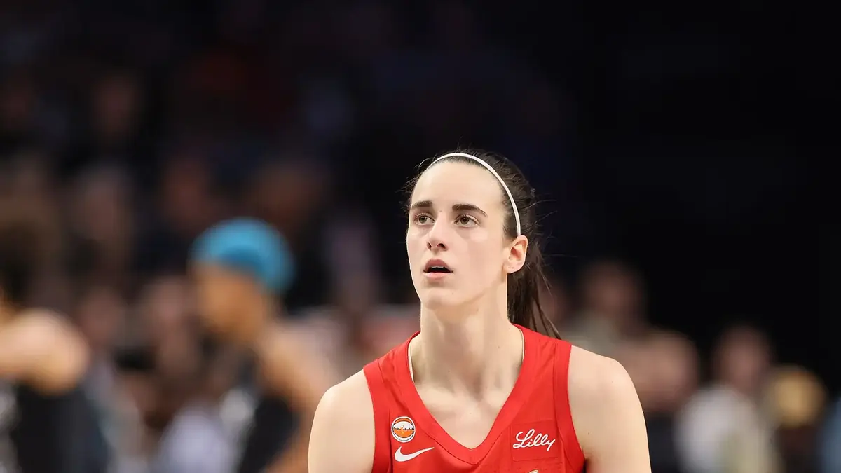 Caitlin Clark of the Indiana Fever dribbling in a white jersey.