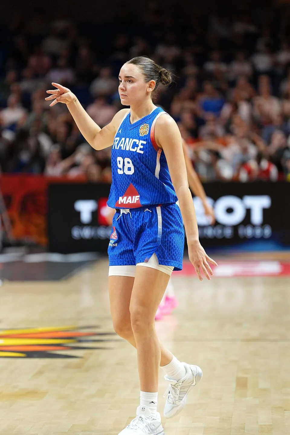 Pauline Astier of France in a blue number 98 jersey holds a basketball with both hands