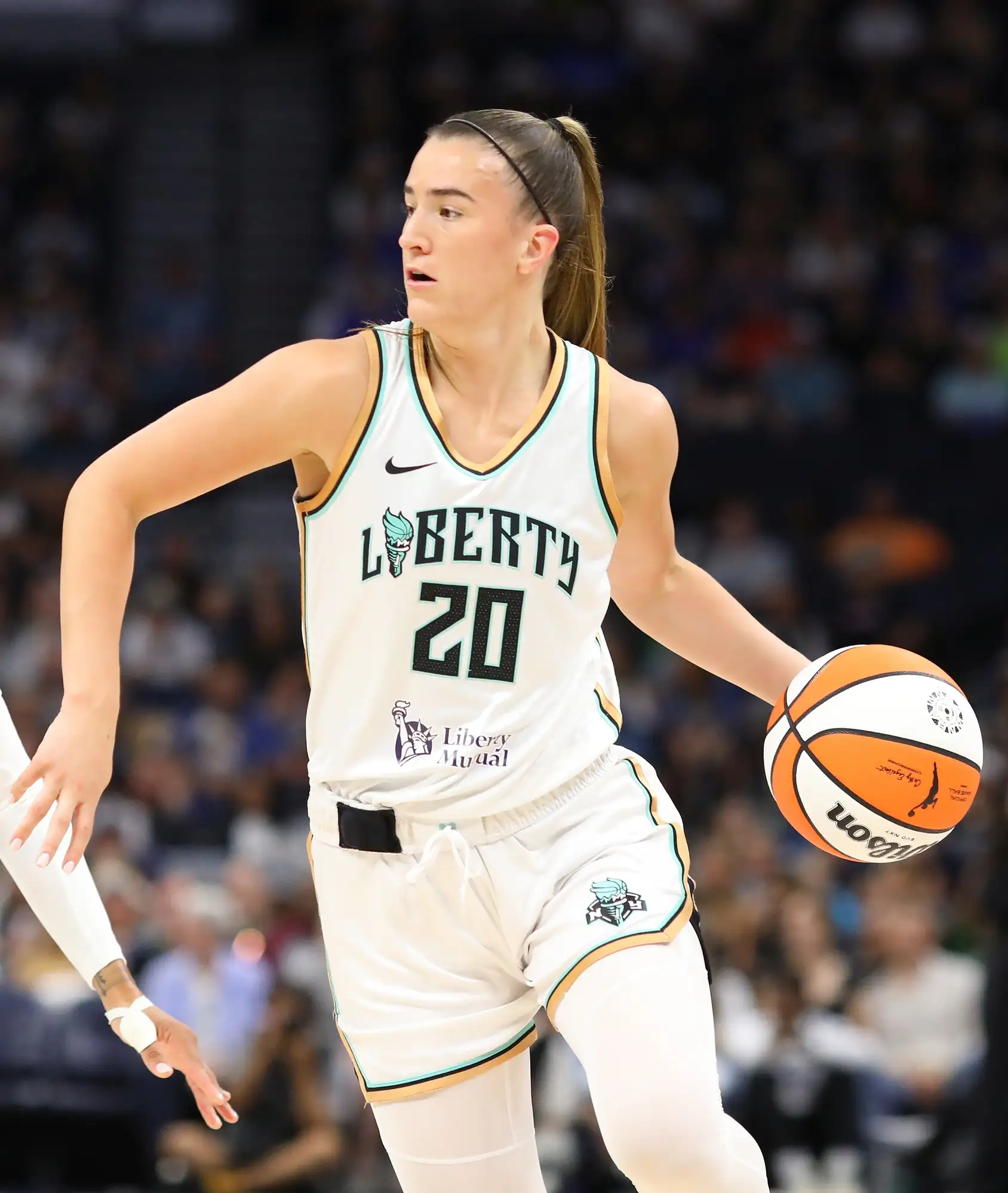 Sabrina Ionescu of the New York Liberty in a white number 20 jersey brings the ball up against the Minnesota Lynx