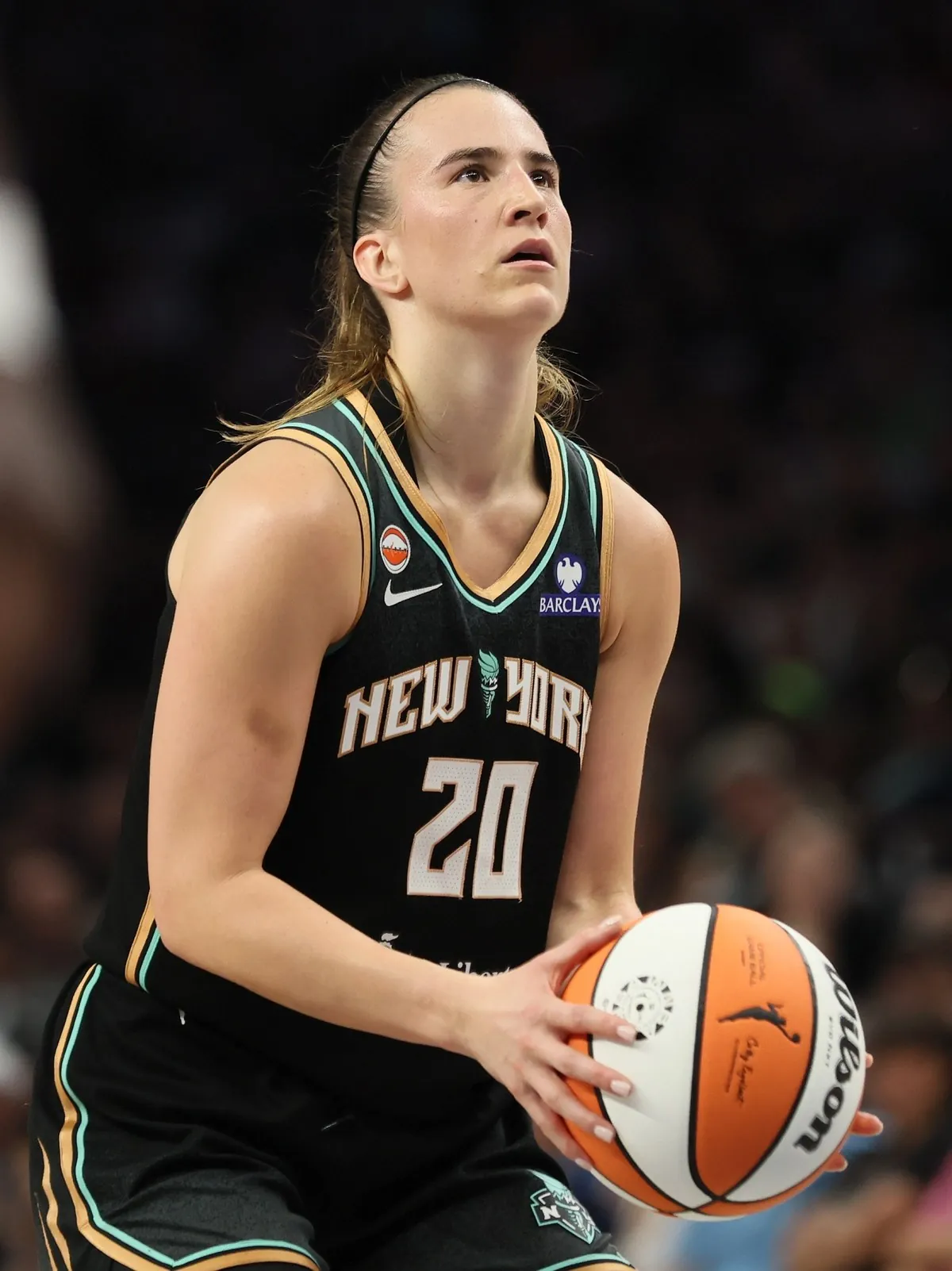 Sabrina Ionescu of the New York Liberty, in a black number 20 Liberty jersey, holds the ball at the free-throw line at Target Center