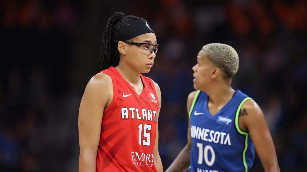 Allisha Gray of the Atlanta Dream in a red No. 15 jersey, next to a Minnesota Lynx player