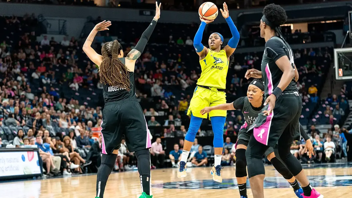 Arike Ogunbowale of the Dallas Wings shooting a jumper over a Minnesota Lynx defender
