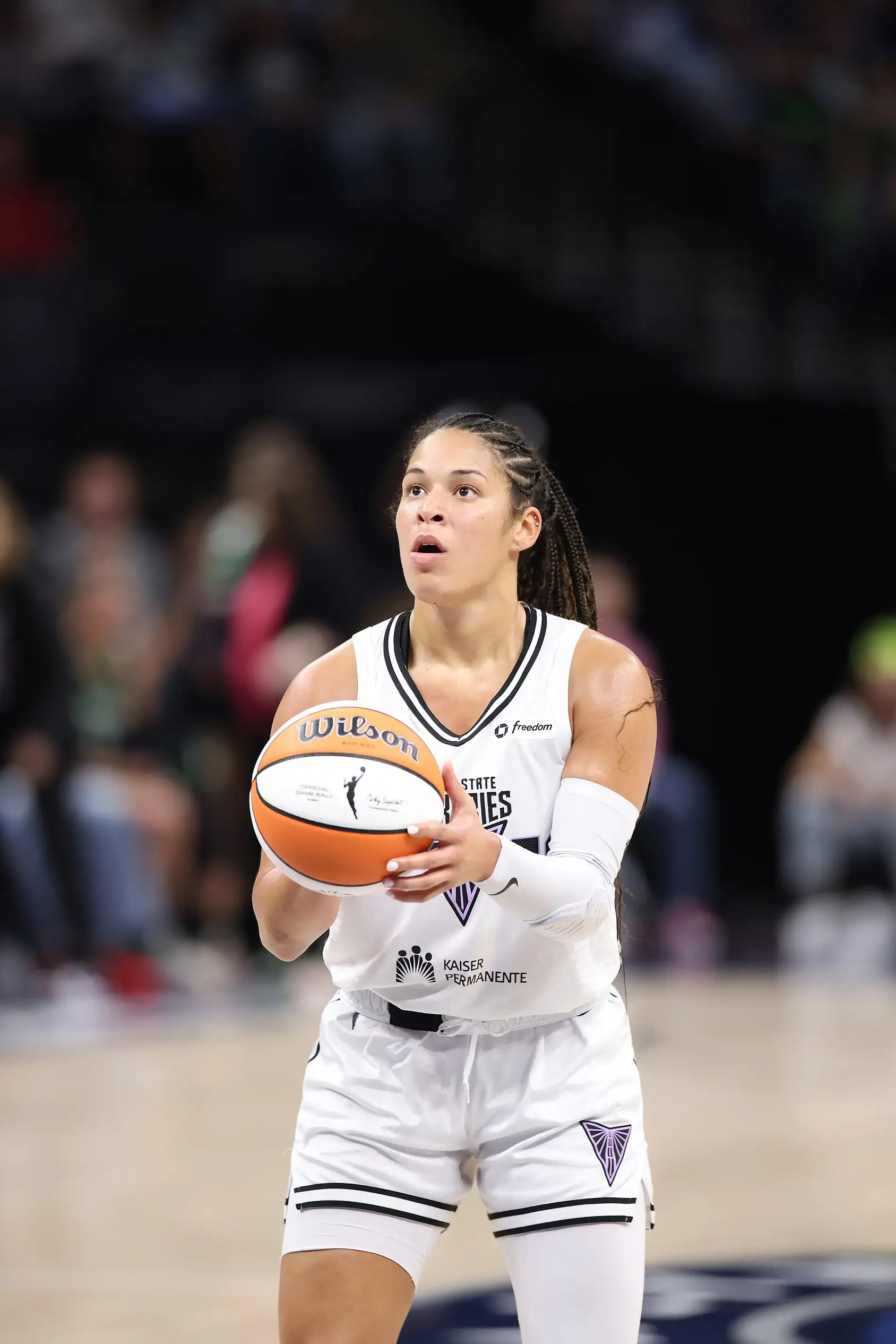 Veronica Burton of the Golden State Valkyries dribbling a basketball in a white jersey against the Minnesota Lynx